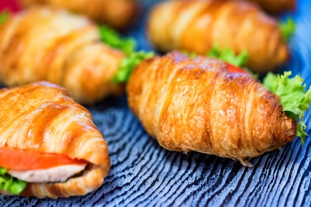 Close up fresh croissants with salad, ham and cheese on tableの写真素材