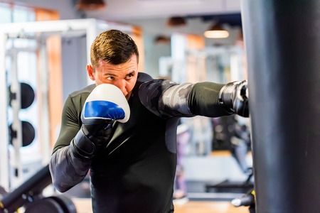 Male boxer does jab punch in modern gymの写真素材