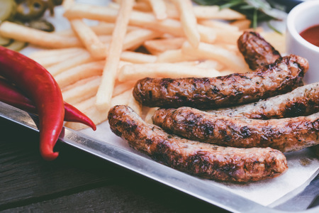Close up meal with sausages, french fries, chili pepper and jalapenoの写真素材