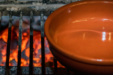 View of glowing charcoal of BBQ grill and empty plate next to itの写真素材