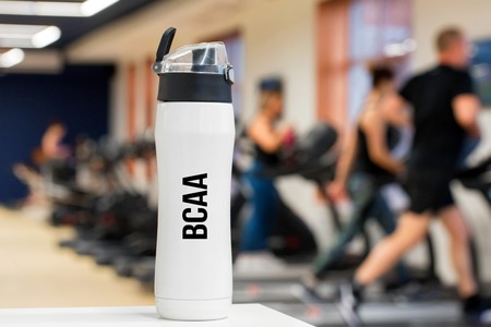 Plastic bottle or cup with BCAA fitness drink close upの写真素材