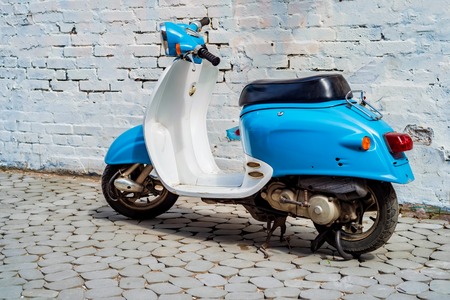Blue retro scooter parked on city street