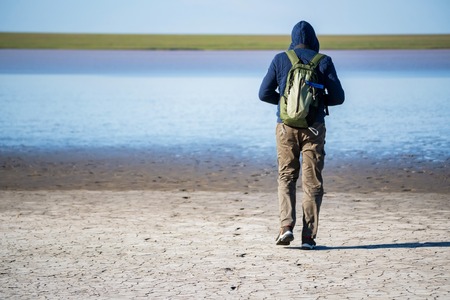Back view young male hiker in natural reserve near water reservourの写真素材