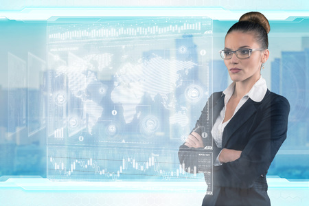 Young business lady works with virtual graphic interface in futuristic officeの写真素材