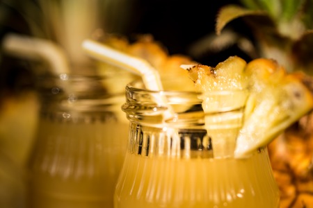 Pineapple juice and slice placed on a wooden tableの写真素材