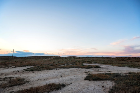 Semi-desert landscape with rural road and skyの写真素材