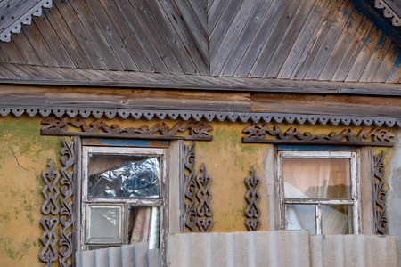Close up facade of old rural house. View of broken windows with wooden decorationの写真素材