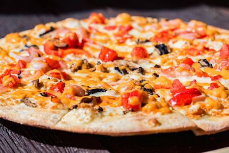 Delicious fresh pizza with tomatoes, mushrooms and cheese close upの写真素材