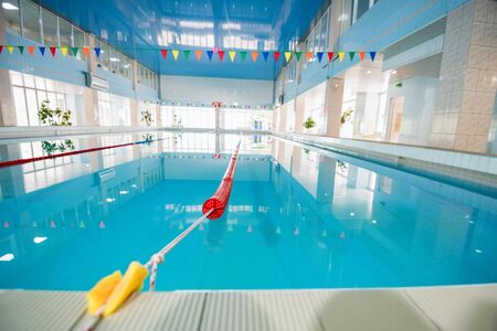 Interior of empty public swimming pool with decorative flags