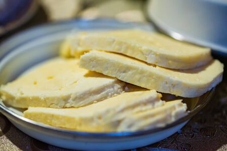 Homemade cheese Bryndza cut in slices in bowl close