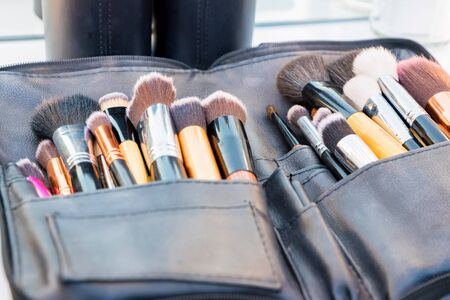 Close up various professional make up brushes lying in dark caseの写真素材