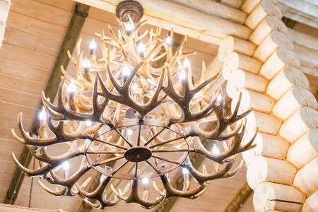 Decorative deer horns chandelier hanging from ceiling close upの写真素材