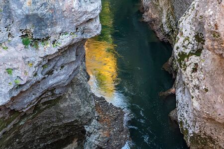 Fall landscape with quick narrow mountain river with clean waterの写真素材
