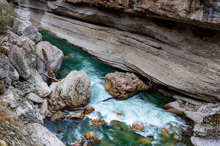 Fall landscape with quick narrow mountain river with clean water