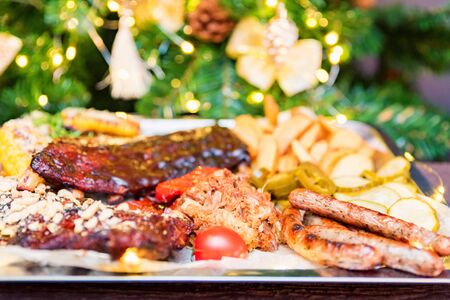 Combo snack composition on tray. Grilled ribs in sauce, chicken, potato wedges, sausages, corn and...