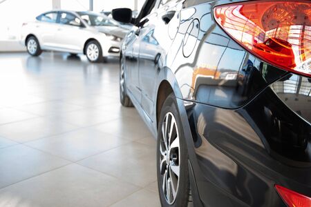 Stock of cars in showroom of automobile dealer with sunlight from window