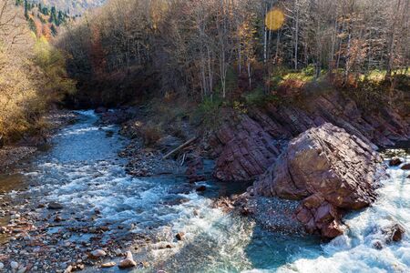 Beautiful autumn landscape with clear mountain river running between rocks