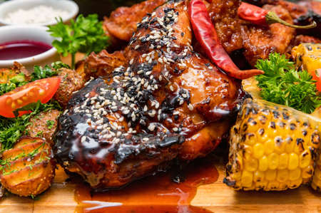 Barbecue chicken with vegetables on wooden tableの写真素材