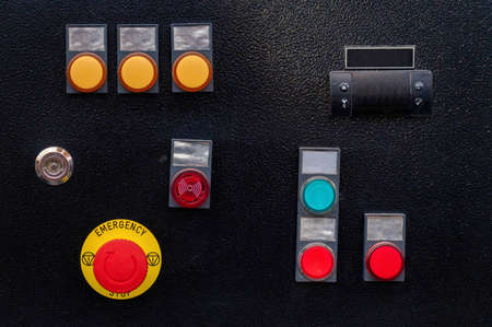 Industrial control panel at factory with yellow and red buttons