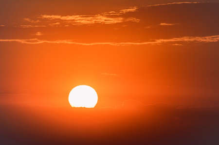Dramatic sunset sky with dark clouds and red sunの写真素材