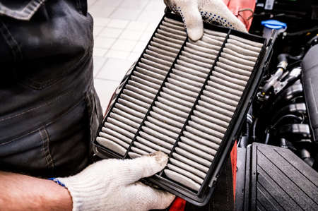 Hand of mechanik is holds car air filter