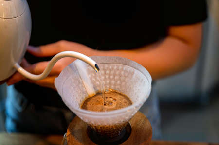 Close up of barista making brewed coffee with paper coffee filters