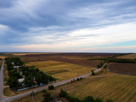 Beautiful sky over the hill in the countryside. Green trees and housesの写真素材