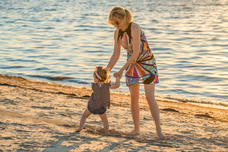 Close up of woman and baby girl playing on the beach