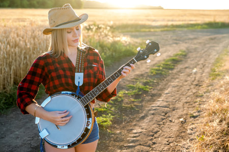 A country girl with a banjo stays in a fieldの写真素材