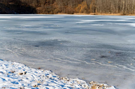 A river bank covered with snow and iceの写真素材