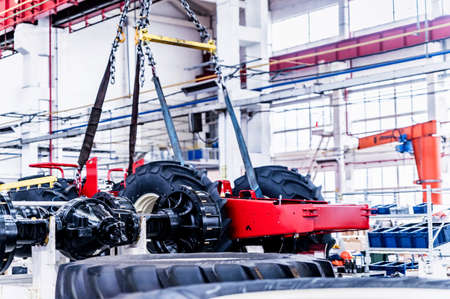 Big tractor wheels installation at assembly room at industrial plantの写真素材