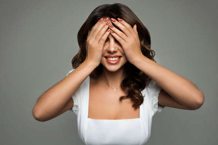Beautiful girl with her hands covering her eyes. Surpise concept