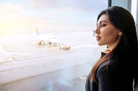 Girl at the airport window waits for a flightの写真素材