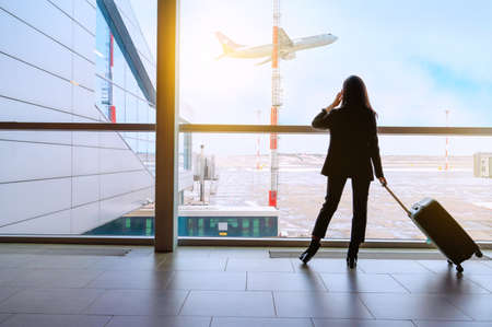 Girl at the airport window waits for a flightの写真素材
