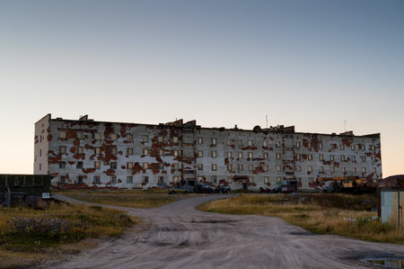 An abandoned multi-storey building stands in the middle of the field.の写真素材
