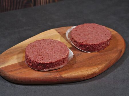Raw vegan plant based burgers on cutting boardの写真素材