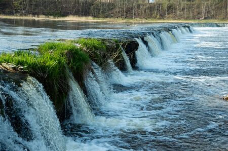 Beautiful waterfall in the river with green grass, waterの写真素材