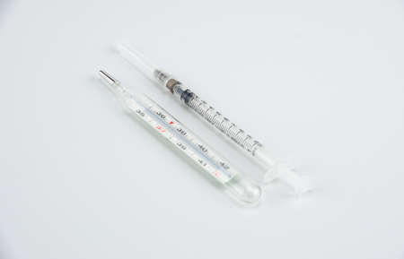 Medical syringe and thermometer on whiteの写真素材