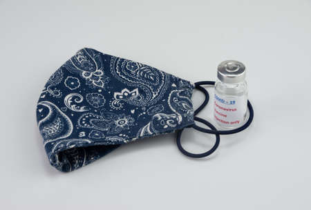 Homemade face mask and vaccine on whiteの写真素材
