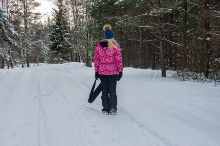 Blonde girl in the forest in winter with a lot of snow, in the forest by car road, white