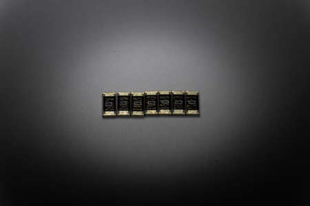 Abstract macro close-up of SMT surface mount chip resistors smart power electronics components isolated on white background mounted with precision equipmentの写真素材