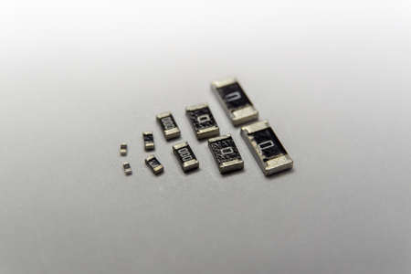 Abstract macro close-up of SMT surface mount chip resistors smart power electronics components isolated on white background mounted with precision equipmentの写真素材