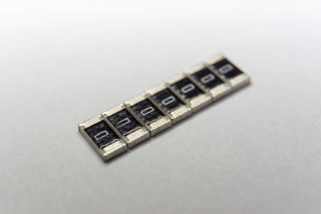 Abstract macro close-up of SMT surface mount chip resistors smart power electronics components isolated on white background mounted with precision equipmentの写真素材