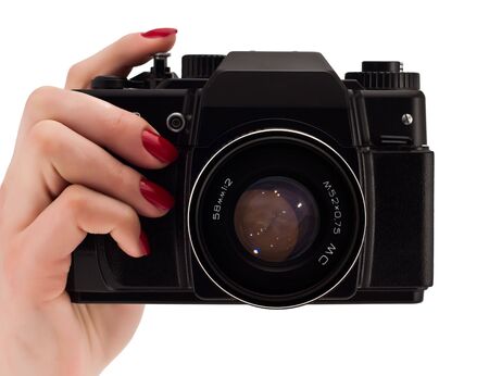 Woomans hand with red nails holding a camera isolated on whiteの写真素材