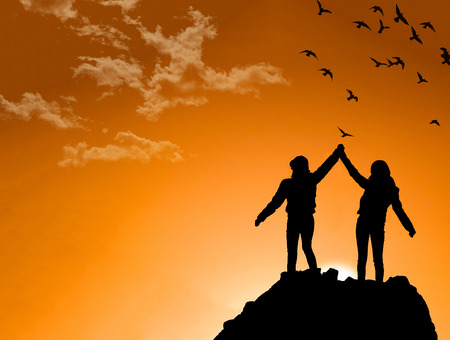 friends on Top of a Mountain Shaking Raised Handsの写真素材