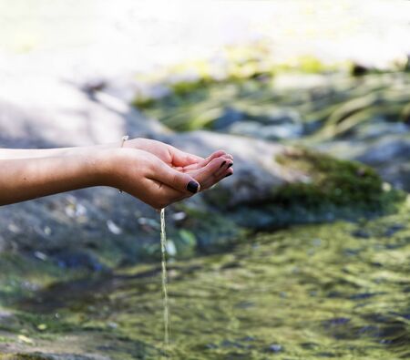 At the edge of the stream,Girl drinking waterの写真素材