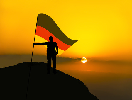 silhouette man winner waving germany flag on top of the mountain peakの写真素材