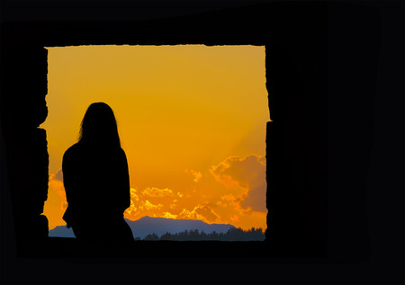lonely girl silhouette sitting at sunsetの写真素材