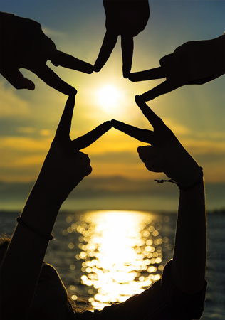 Many hands connecting to star shape at sunset, Teamwork Conceptの写真素材