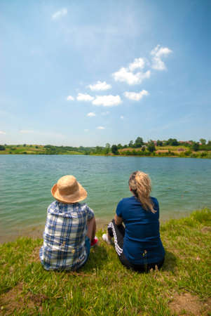 two people sitting by the waterの写真素材